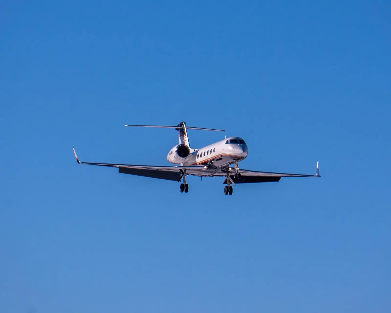 Business jet on approach against a clear blue sky