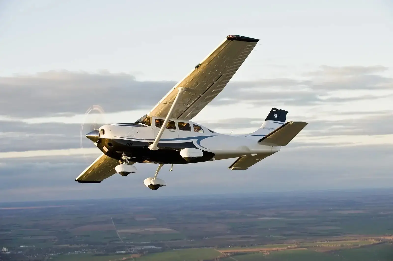 Light charter aircraft in flight above the clouds