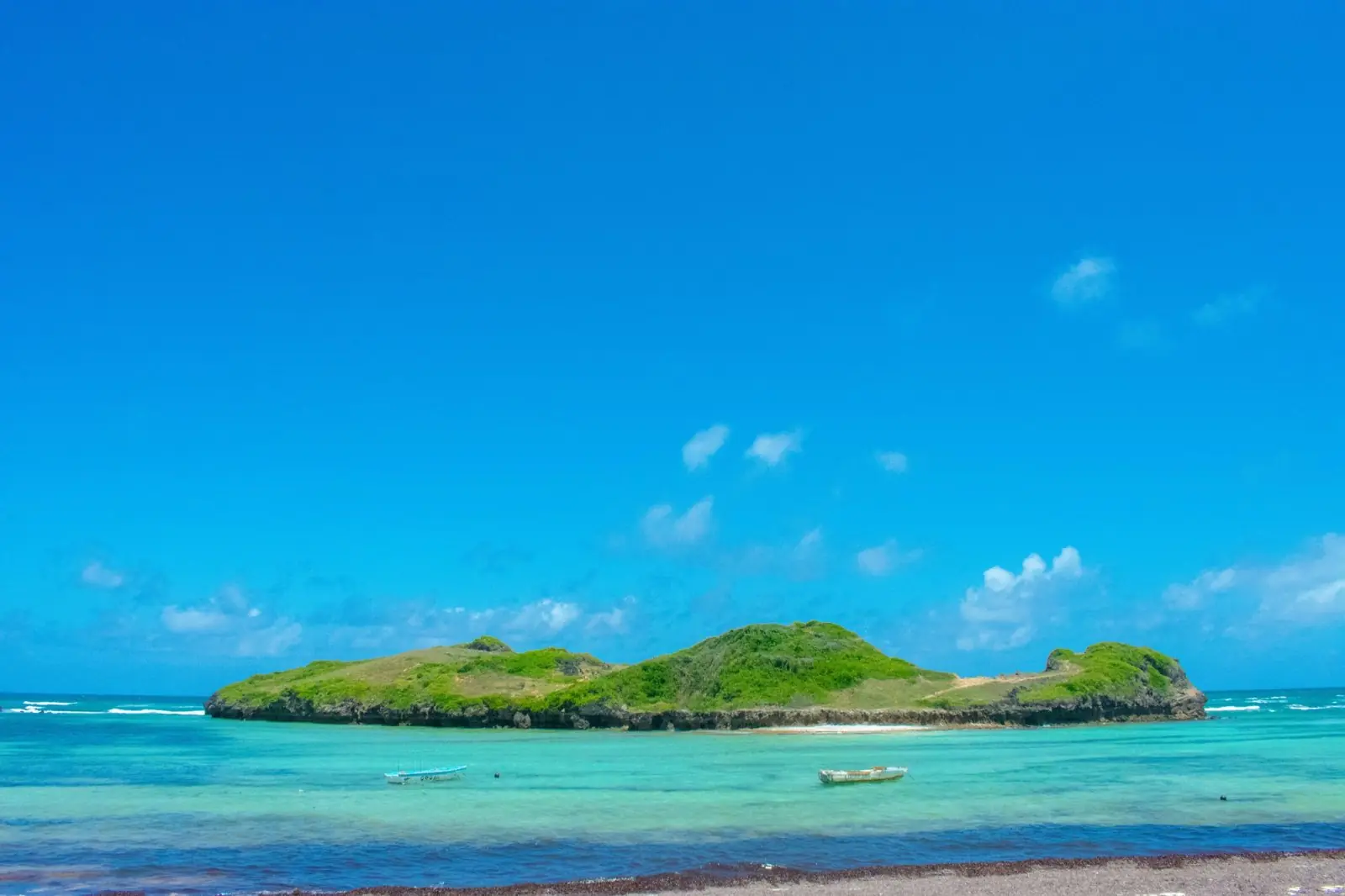 Green coral island in turquoise water off the north coast